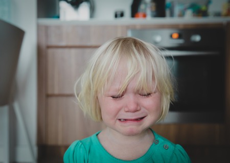 crying little girl at home, kids despairの写真素材