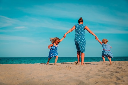 mother with two daughters play at beachの写真素材