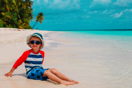 cute little boy play with water and sand on beachの写真素材