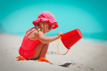 cute little girl play with sand and toys on beachの写真素材
