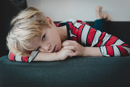 sad boy, stressed and tired kid at homeの写真素材