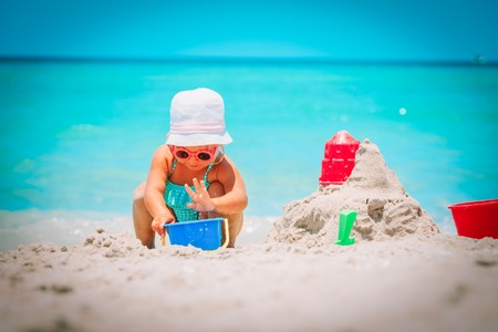 cute little girl play with sand on beachの写真素材