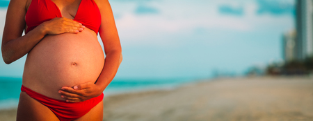 Happy pregnant woman at city beach vacationの写真素材