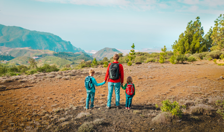 father with son and daughter hiking in mountainsの写真素材