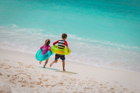 little girl and boy run swim on beachの写真素材