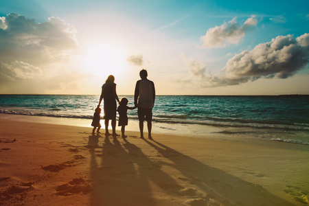 happy family with kids walk at sunset beachの写真素材