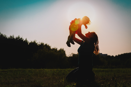 mother and little baby play in sunset natureの写真素材