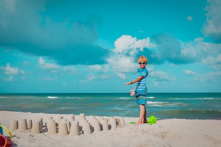 young boy play with sand at beachの写真素材