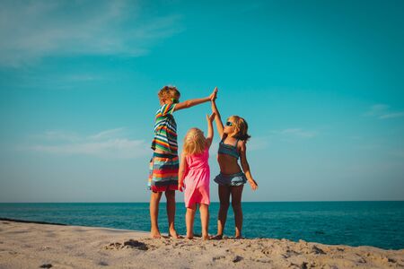 happy kids play on beach, boy and girls have fun at seaの写真素材