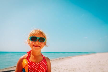 sun protection concept - cute girl with suncream at beach