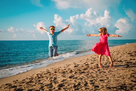 happy cute boy and girl enjoy play jump on beachの写真素材