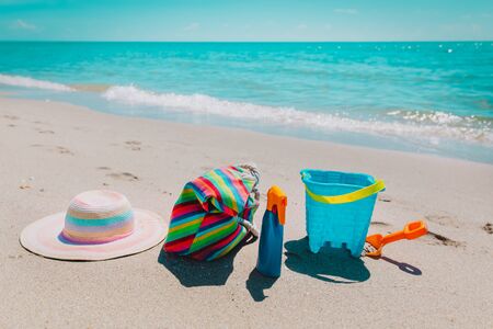 hat, bag ,suncream and toys on beachの写真素材