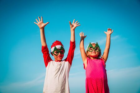 happy kids- little boy and girl- celebrating christmas on tropical beachの写真素材