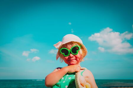 cute little girl with bag on beach vacationの写真素材