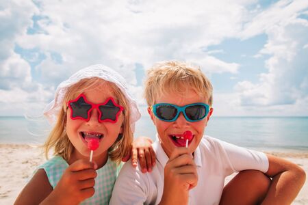 happy little girl and boy with lollipop on summer vacationの写真素材