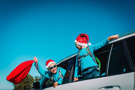 christmas car travel- happy boy and girl enjoy travel in winter natureの写真素材