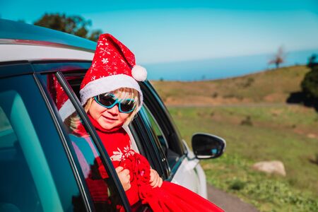 christmas car travel- happy little baby girl loves travel in winterの写真素材