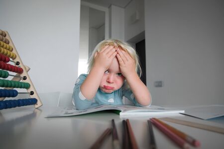 little girl tired and stressed of reading, doing homework