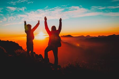 happy mother and son travel in mountains at sunset