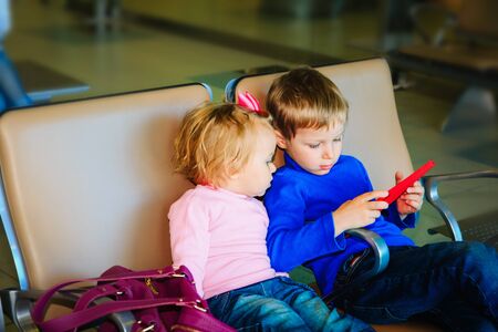 boy and girl looking at touch pad while travel in the airportの写真素材