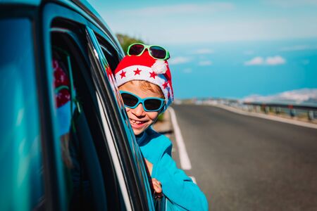 christmas car travel- happy child travel on road in winterの写真素材