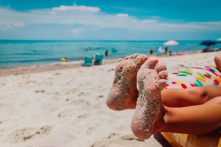 relax on sea vacation-kids feet on floatie at beach