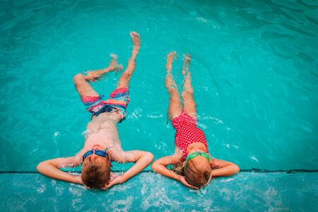 little boy and girl relax in pool, family on beach resortの写真素材