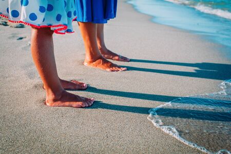 Mother with little daughter walk on sand beachの写真素材
