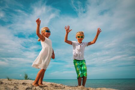 cute boy and girl dance at beach, kids enjoy vacation at sea