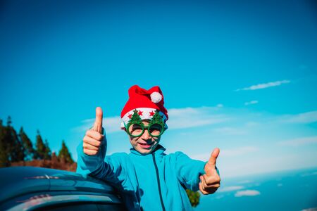 christmas car travel- happy child travel on road in winterの写真素材