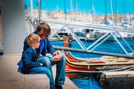 father and little son looking at map on the quay of Valetta, Maltaの写真素材