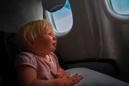 happy little baby girl travel by plane