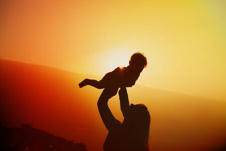 mother and little daughter play at sunset natureの写真素材