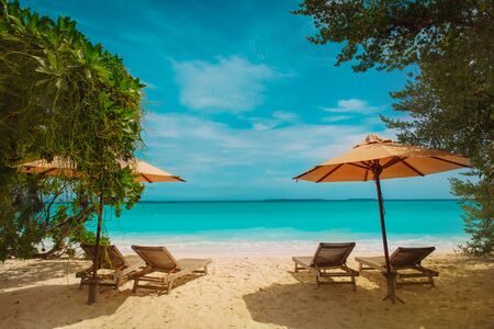 Beach chairs on tropical vacation, relax at sea, travel concept