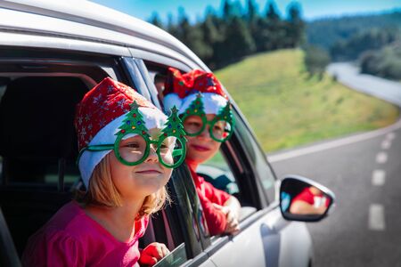 christmas car travel- happy boy and girl travel in winterの写真素材
