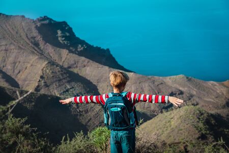 Happy young boy hiking in mountains near sea, family vacation in Canary islandsの写真素材