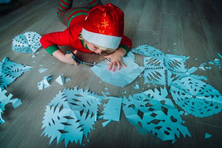 little girl cutting snowflakes from paper, Christmas craftsの写真素材