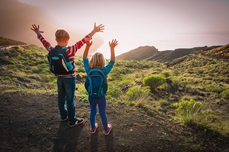 happy boy and girl travel in mountains at sunset, kids enjoy hiking, family vacationの写真素材