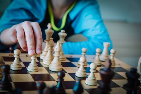 boy learning to play chess, kid making move in gameの写真素材