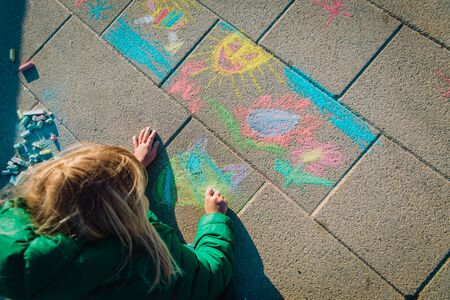 kids play outdoors - little girl drawing pictures on asphalt, after school activitiesの写真素材