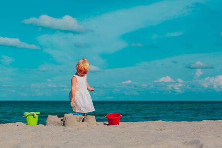 cute little girl play with sand on beach