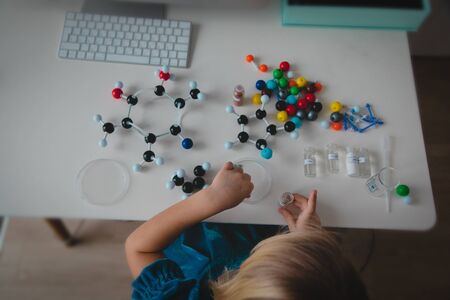 little girl making model of a molecule, learning chemistry, online learning and STEM