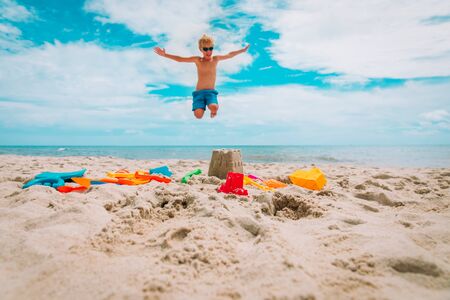 toys on sand beach and happy boy enjoy tropical vacationの写真素材