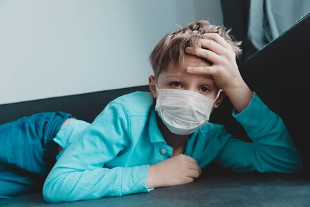 Sick child with infection or virus, boy wearing mask on quarantine at homeの写真素材