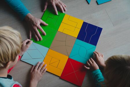 teacher and kids play with puzzle, doing tangramの写真素材
