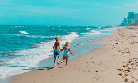 happy boy and girl running on beach