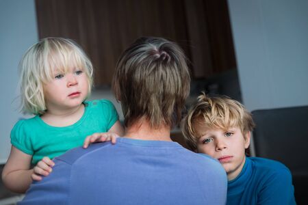 sad boy and girl hugging father, anxiety in family, dad and kids staying homeの写真素材