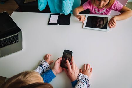 family on distant learning, dad and kids using laptop, touch pad, mobile phone and e-book, remote...