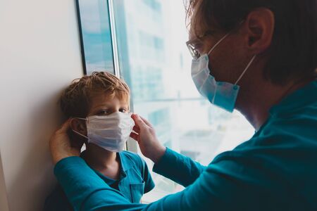 father put mask on son before going outsideの写真素材