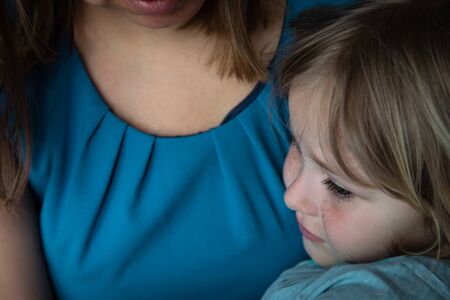 sad crying little girl hugging mother, kids anxiety and stress, family careの写真素材